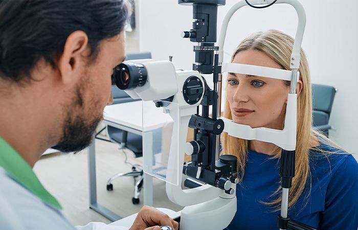 an optometrist works with a patient